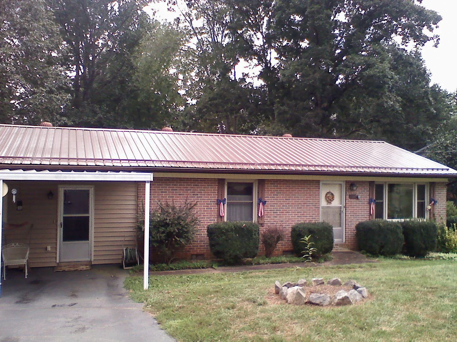 Bronze metal roof and carport on a brick ranch home — Roof Repair work by our crew in Cherokee